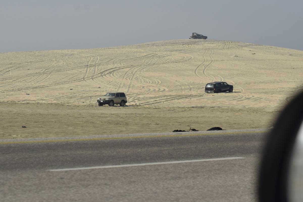 Sand Dune Navigation Tools including GPS device, compass, and topographic map laid out on a desert vehicle dashboard